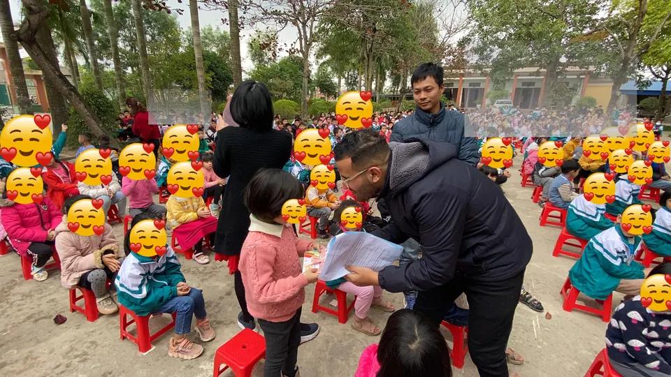 Mr. Nas helping a child speak into a microphone at a school event